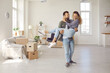 © Studio Romantic - Happy young married couple on threshold of new life. Newlyweds having fun in big new home. Strong man carrying his woman in arms in newly bought modern spacious unfurnished house. Real estate concept