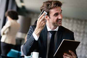 Portrait of a smiling young businessman doing online shopping through computer and credit card