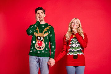 Sticker - Photo portrait curious girl looking amazed man wearing ugly sweater isolated vibrant red color background