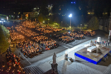 Lourdes, France - 9 Oct 2021: Pilgrims attend the Marian Torchlight Procession service at the Rosary Basilica in Lourdes