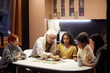 © pressmaster - Big family sitting at the table in the domestic kitchen and playing board games together