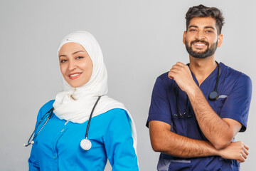 Wall Mural - professional muslim doctor woman and indian assistant discuss tasks. portrait of beautiful medical workers with stethoscopes