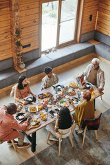 Wall Mural - High angle view of family talking to each other during dinner at dining table at home