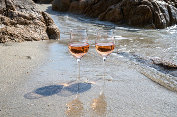 Summer time in Provence, two glasses of cold rose wine on sandy beach near Saint-Tropez, Var department, France