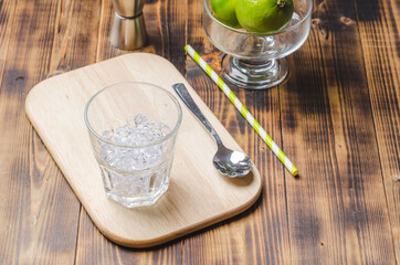 Ice for a cocktail in glass on a wooden table.