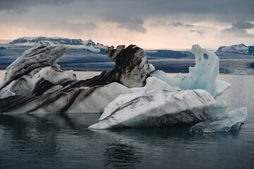 Wall Mural - Icebergs floating. Ices and icebergs. Glacier lagoon. Greenland iceberg. Melting ice. South coast Iceland. Jokullsarlon glacier lagoon. Volcanic ash on the ice. Ice age glacier. Melting iceberg.