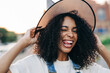 Portrait of young african american woman wearing witch halloween hat grimaces and smile. Lifestyle Halloween concept.