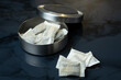 Closeup of a metallic swedish snus can and portion snuff pouches.
