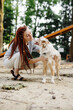 © Oleksii Syrotkin/Stocksy - Woman stroking dog during walk in park