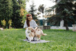 © Oleksii Syrotkin/Stocksy - Female owner fooling around with dog outside