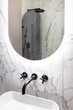© Luciano Spinelli/Stocksy - Rounded mirror in a toilet with a pink and grey shower