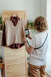 © Sergey Narevskih/Stocksy - Woman taking picture of wardrobe for ad on internet