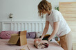 © Sergey Narevskih/Stocksy - Woman packing wear in box for delivery
