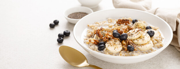 Poster - Oatmeal bowl. Oat porridge with banana, blueberry, walnut, chia seeds and almond milk for healthy breakfast or lunch. Healthy food, diet. Banner.