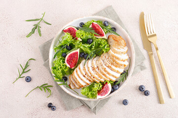 Wall Mural - Chicken breast baked and fresh salad of lettuce, arugula, blueberry and figs. Healthy diet food. Top view.