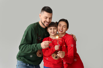 Poster - Happy family with Christmas sparklers on light background