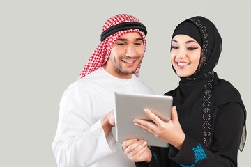 Wall Mural - Saudi young arabian man and woman holding a digital gadget