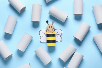 Bee made of cardboard and tubes for toilet paper on blue background