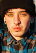 Vertical shot of a young Caucasian man with nose piercings and a black hat in Argentina