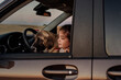 © Eloisa Ramos/Stocksy - Girl with her puppy inside a car enjoying the sunset