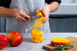 © Pietro Karras/Stocksy - Chef putting cut mango into glass jar