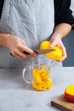Chef Putting Cut Mango Into Glass Jar