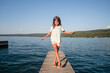 © Maria Manco/Stocksy - Girl does yoga poses on dock of lake