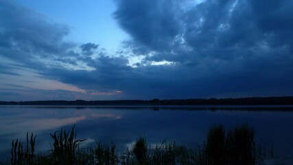 Wall Mural - Blue hour, clouds over water, time-lapse