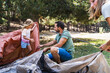 © Manu Padilla/Stocksy - Parents setting up tent with daughter