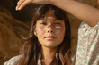 © Nicole Mason/Stocksy - portrait of woman holding hand up to the sun
