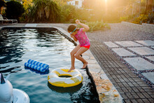 Girl In Goggles Jumping Into Inflatable Pool Ring