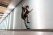 © Santi Nuñez/Stocksy - Low angle view of a young man with roller skates jumping in the city inside of a building
