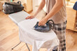 © Martí Sans/Stocksy - Crop male ironing shirt with steam