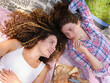 © Miquel Llonch/Stocksy - Happy girlfriends with picnic snack