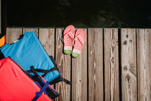 Life-vests And Flip-flops On A Dock By A Lake