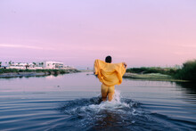 Back Of Wet Man In Suit Walking In Water