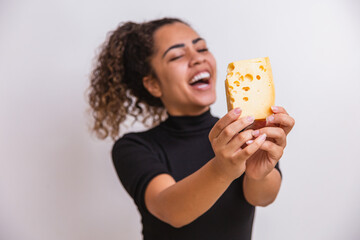 young woman with a slice of cheese in her hand. woman eating parmesan cheese.  focus on cheese