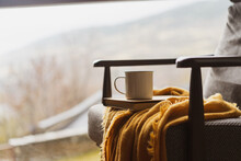 Detail Of Coffe Cup And Book On Top Of Chair By Window