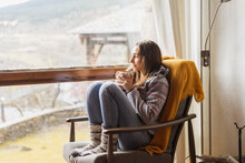 Woman Enjoying A Warm Coffe Cup At Home  By The Window