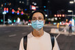 © Heng Yu/Stocksy - Portrait of a man wearing a mask on the street at night