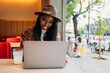 © VICTOR TORRES/Stocksy - Black woman with laptop and lemonade sitting in cafe