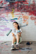 © MaaHoo Studio/Stocksy - Portrait of happy girl with graffiti