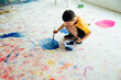 Asian boy painting on the ground