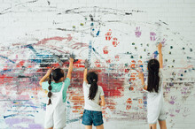 Asian Girls Painting On The Wall