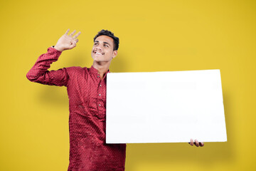 Wall Mural - young indian man holding white board while wearing traditional cloths
