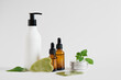 cosmetics jar, cream in a bottles with a dispenser, serum in dropper bottle and a gua sha scraper made of jadeite stone