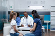 © DC Studio - African american pediatrician doctor writing disease expertise on clipboard discussing medical treatment with family during clinical appointment in hospital office. Health care treatment