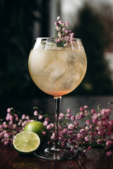 fresh spritz cocktail with lime and ice cube in wineglass