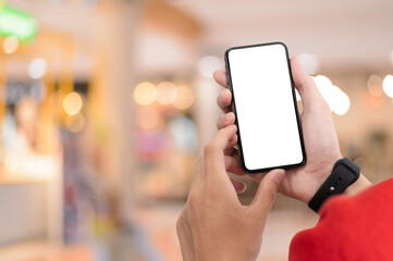 Man holding smart phone with blurred background.