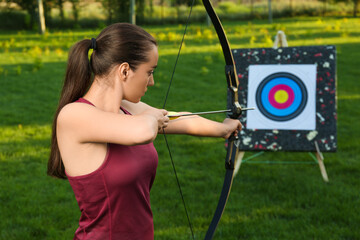 Sticker - Woman with bow and arrow aiming at archery target in park